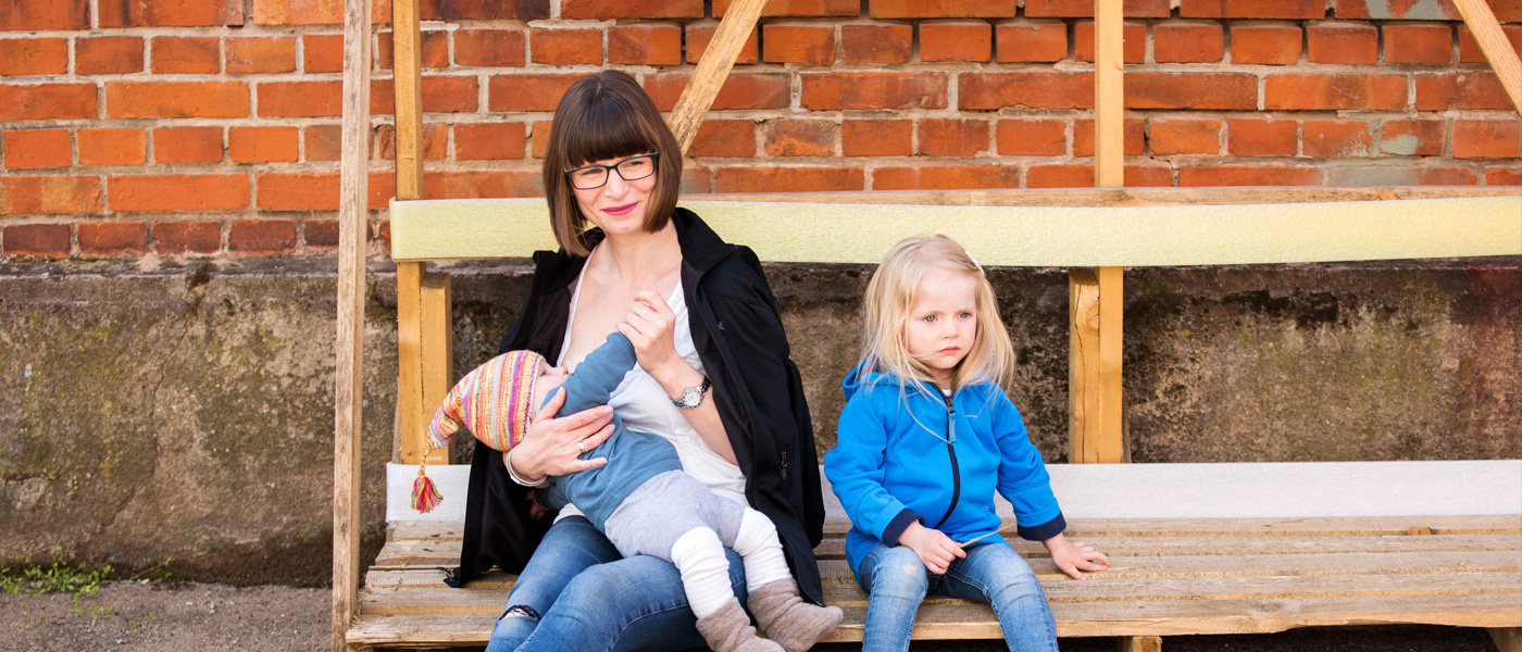 Stillende Mutter mit Geschwisterchen
